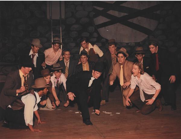 A group of boys in costume singing on stage